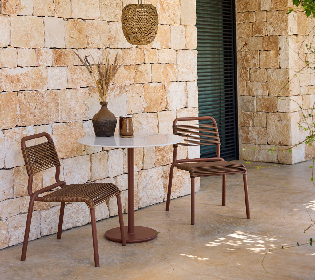 Configuración moderna de salón con sillas marrones y una mesa blanca.