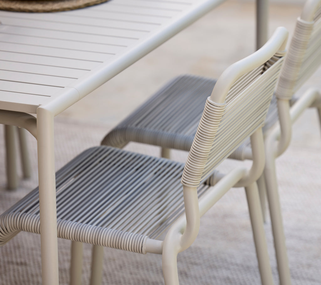 Mesa de comedor moderna con acabado blanco y sillas grises.