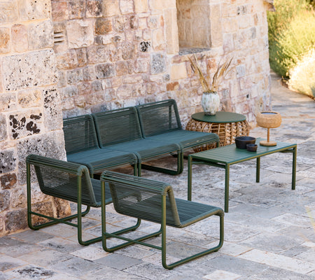 Sofá y sillas verdes modernos con una mesa a juego en un ambiente de salón informal.