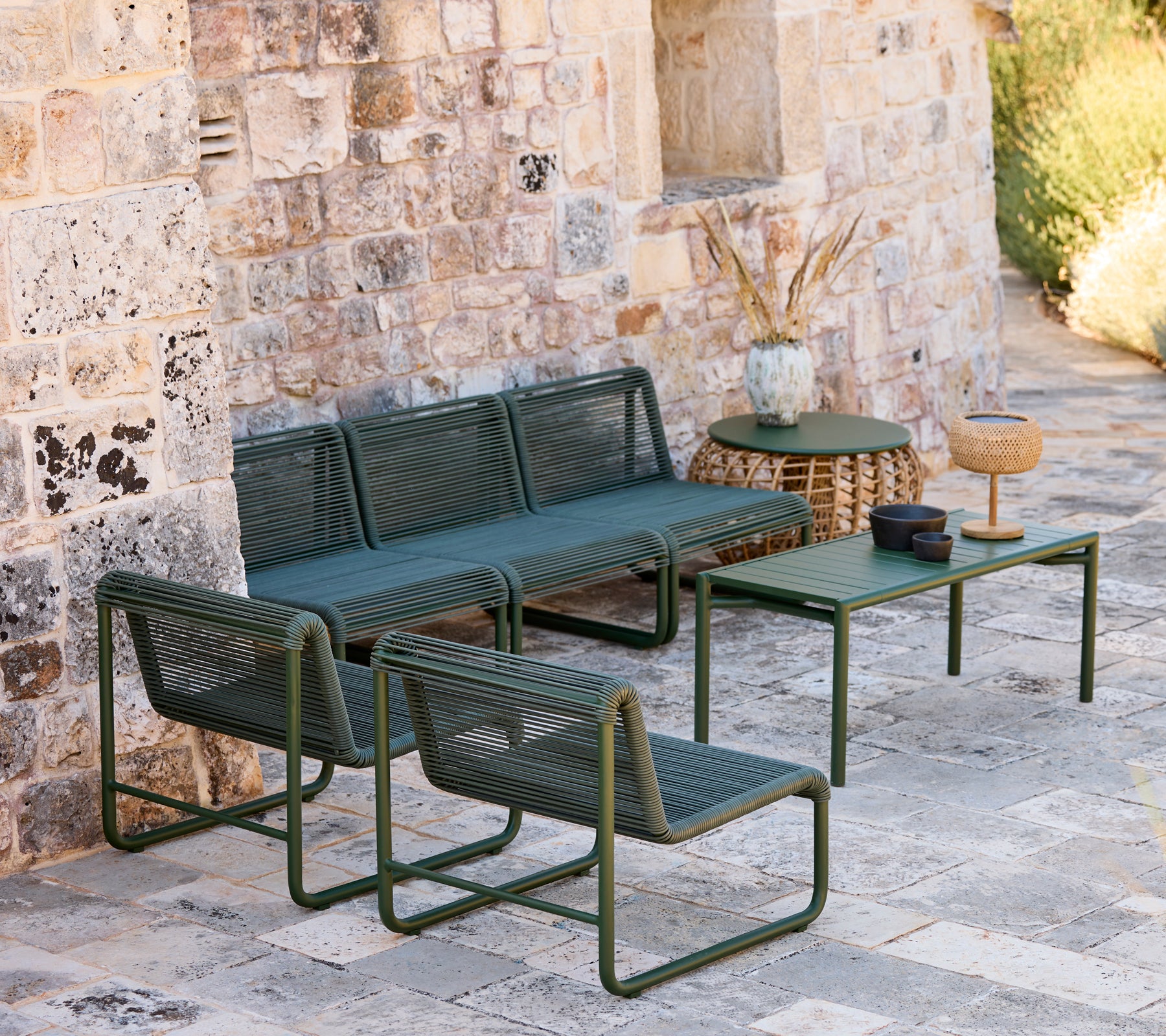 Sofá y sillas verdes modernos con una mesa a juego en un ambiente de salón informal.