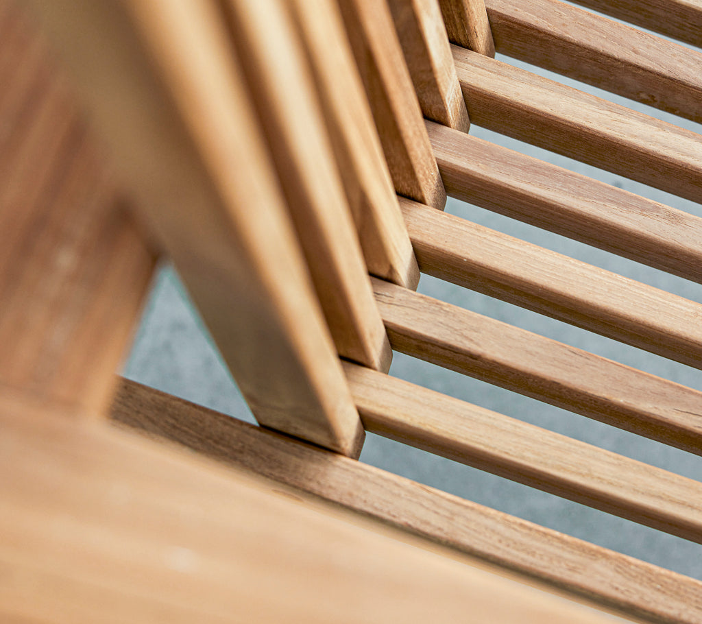 Vista en primer plano de lamas de madera, mostrando el grano y la textura natural en una disposición estilizada.