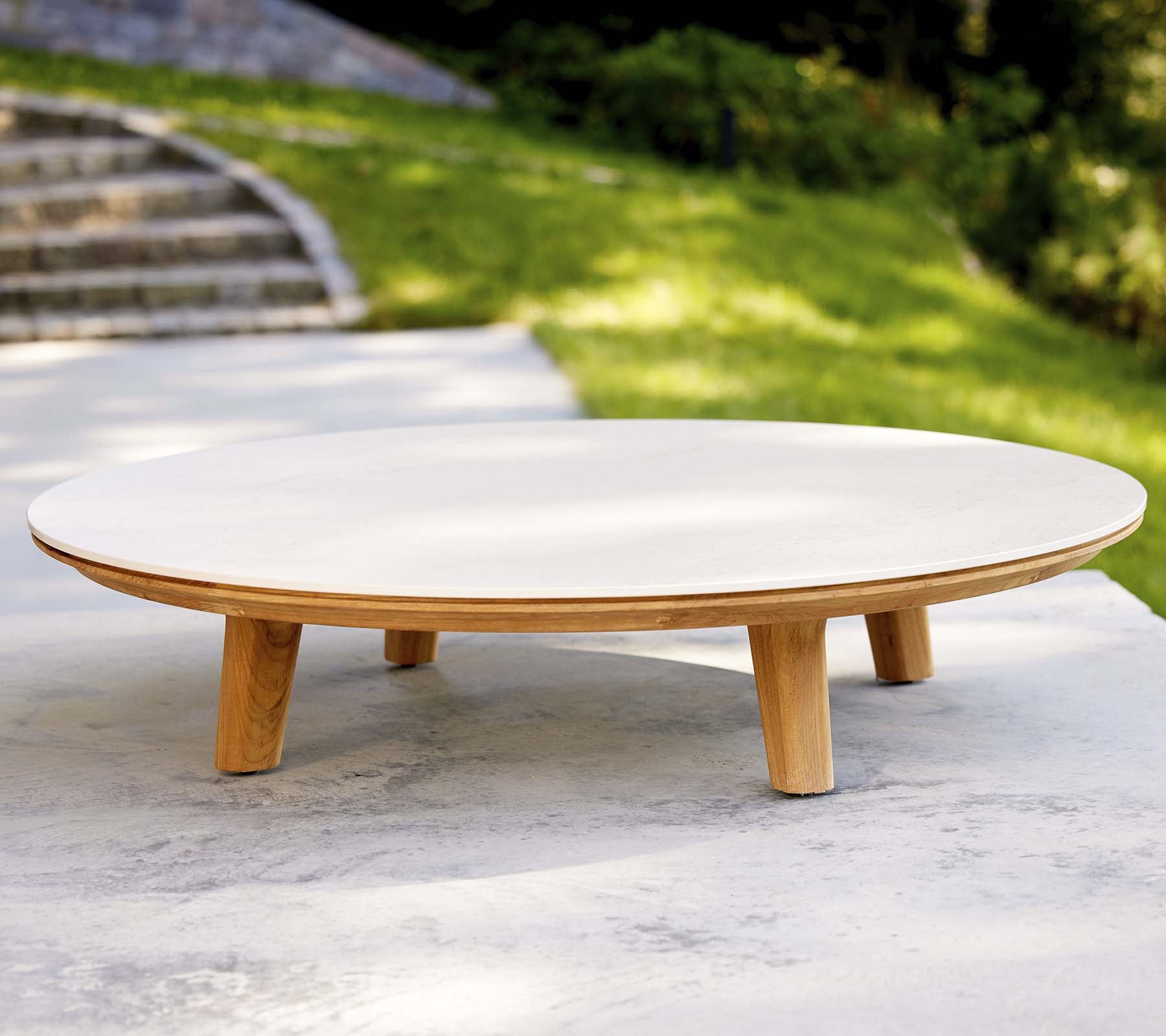 Mesa de café redonda moderna con una superficie lisa y patas de madera, con un diseño minimalista adecuado para diversos entornos.