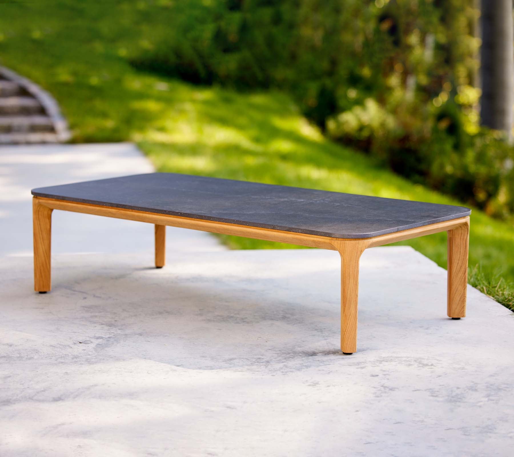 Una mesa de café elegante con una superficie oscura y patas de madera clara, ideal para espacios de vida modernos.