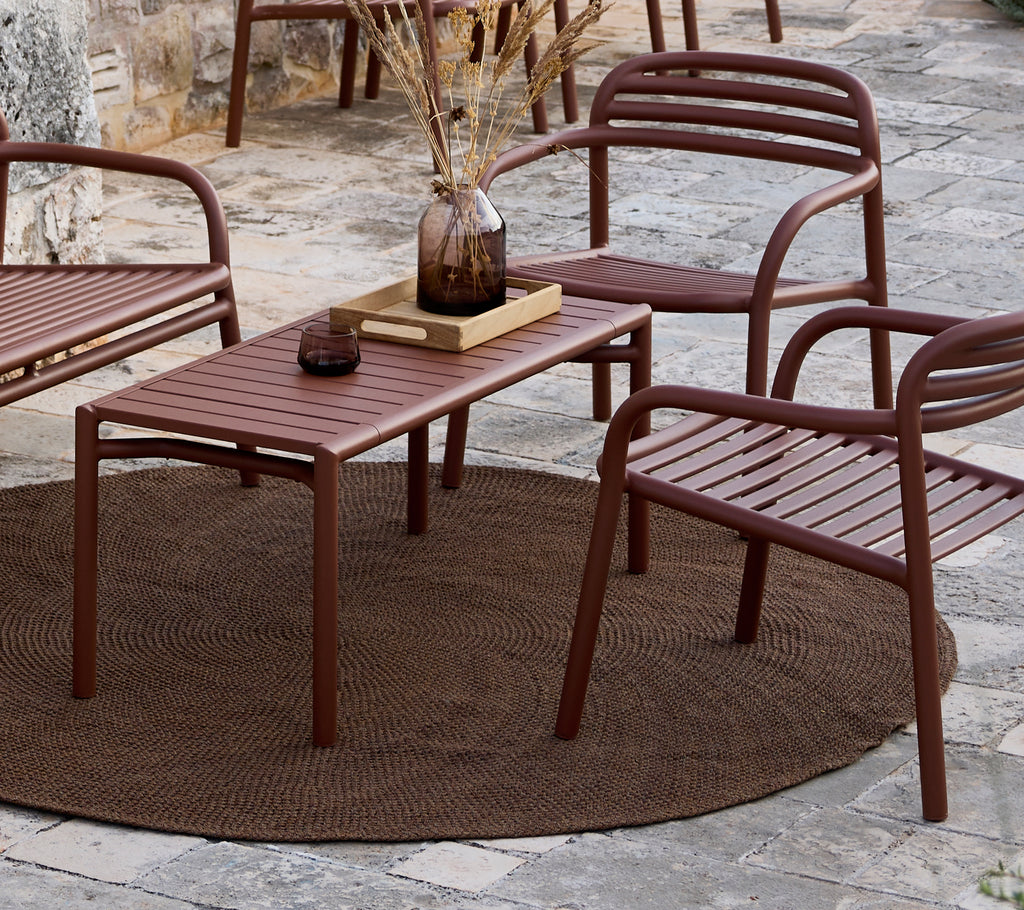 Mesa y sillas marrones minimalistas dispuestas en un ambiente de salón.