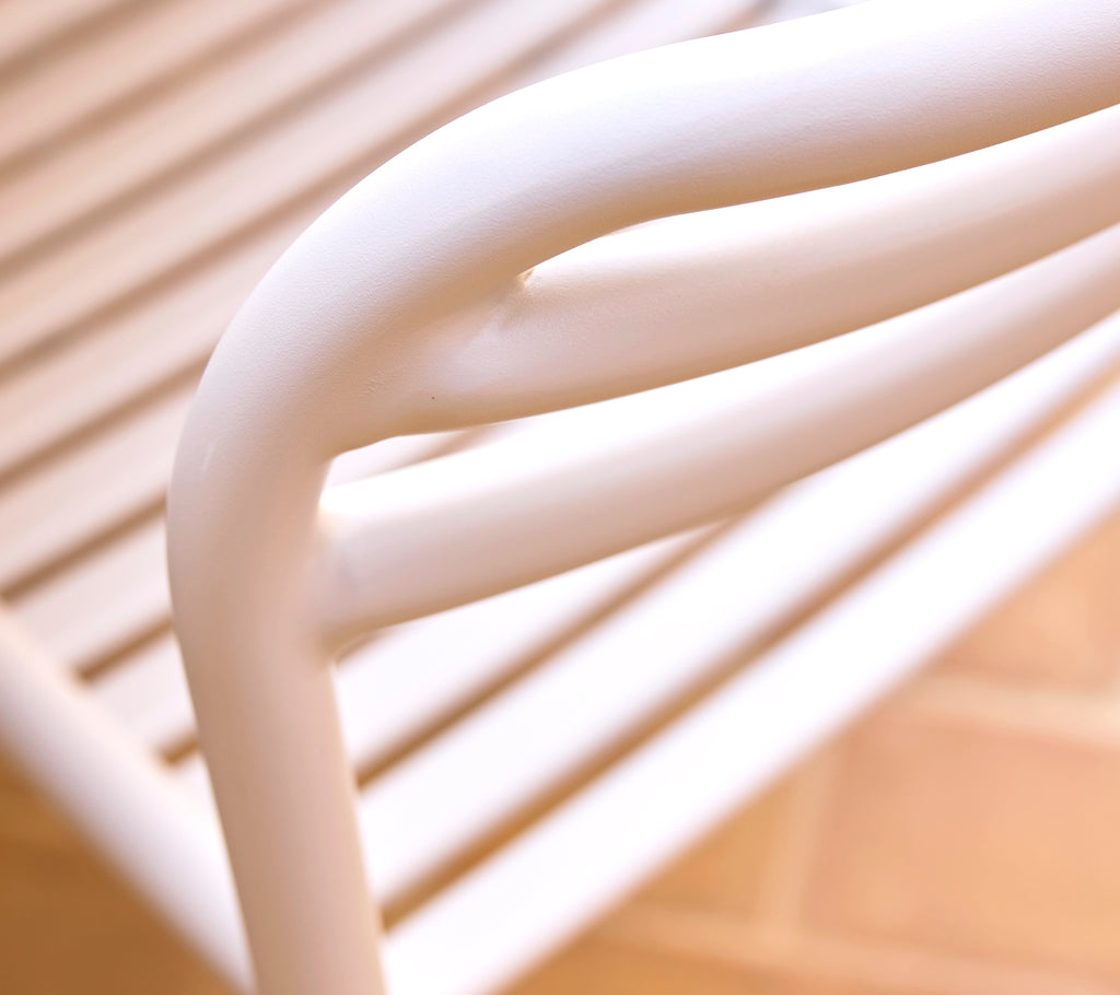 Primer plano de una silla de comedor color arena que muestra líneas suaves y curvas y un diseño elegante, enfatizando el estilo moderno y la comodidad.
