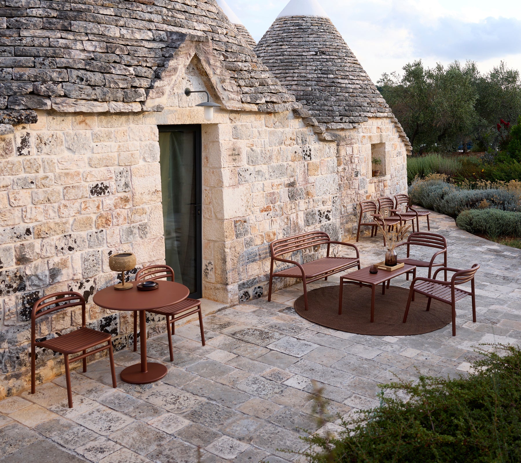 Entorno exterior con una mesa y sillas marrones en un diseño moderno.