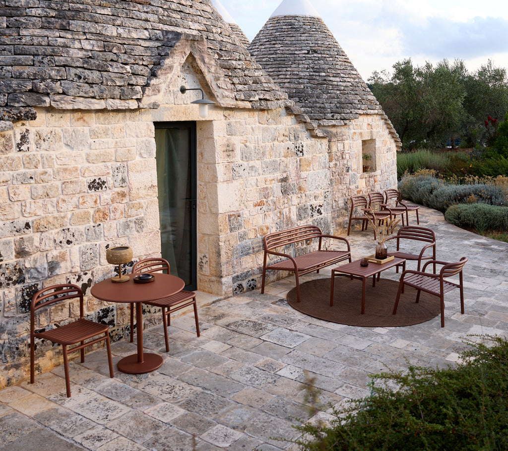 Entorno exterior con una mesa y sillas marrones en un diseño moderno.