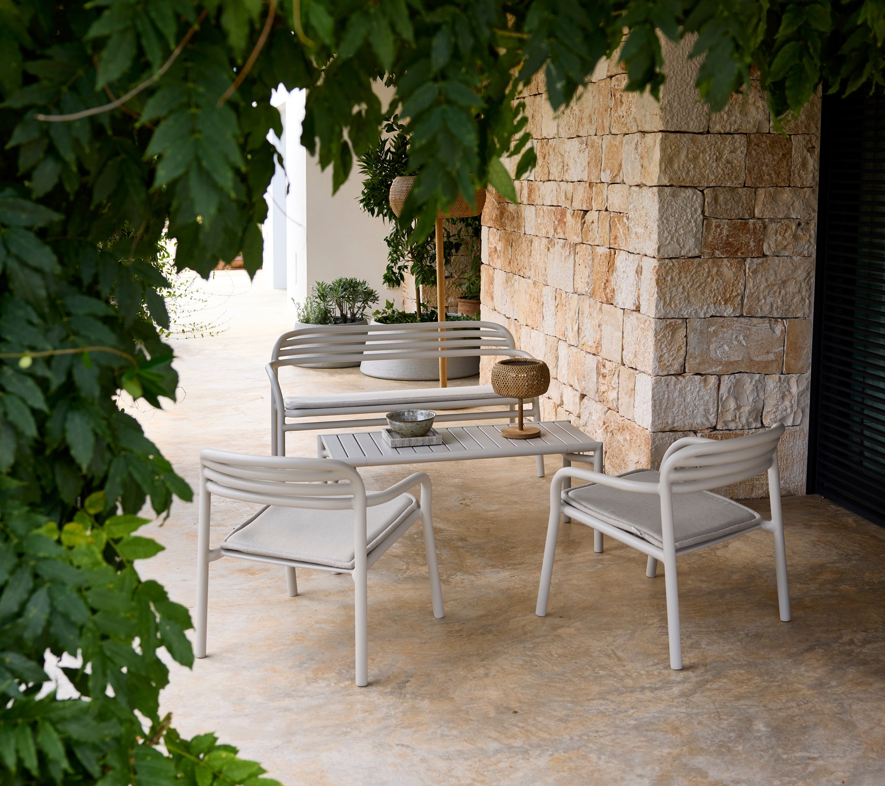 Sofá y sillón grises con una mesa blanca en un ambiente moderno de salón.