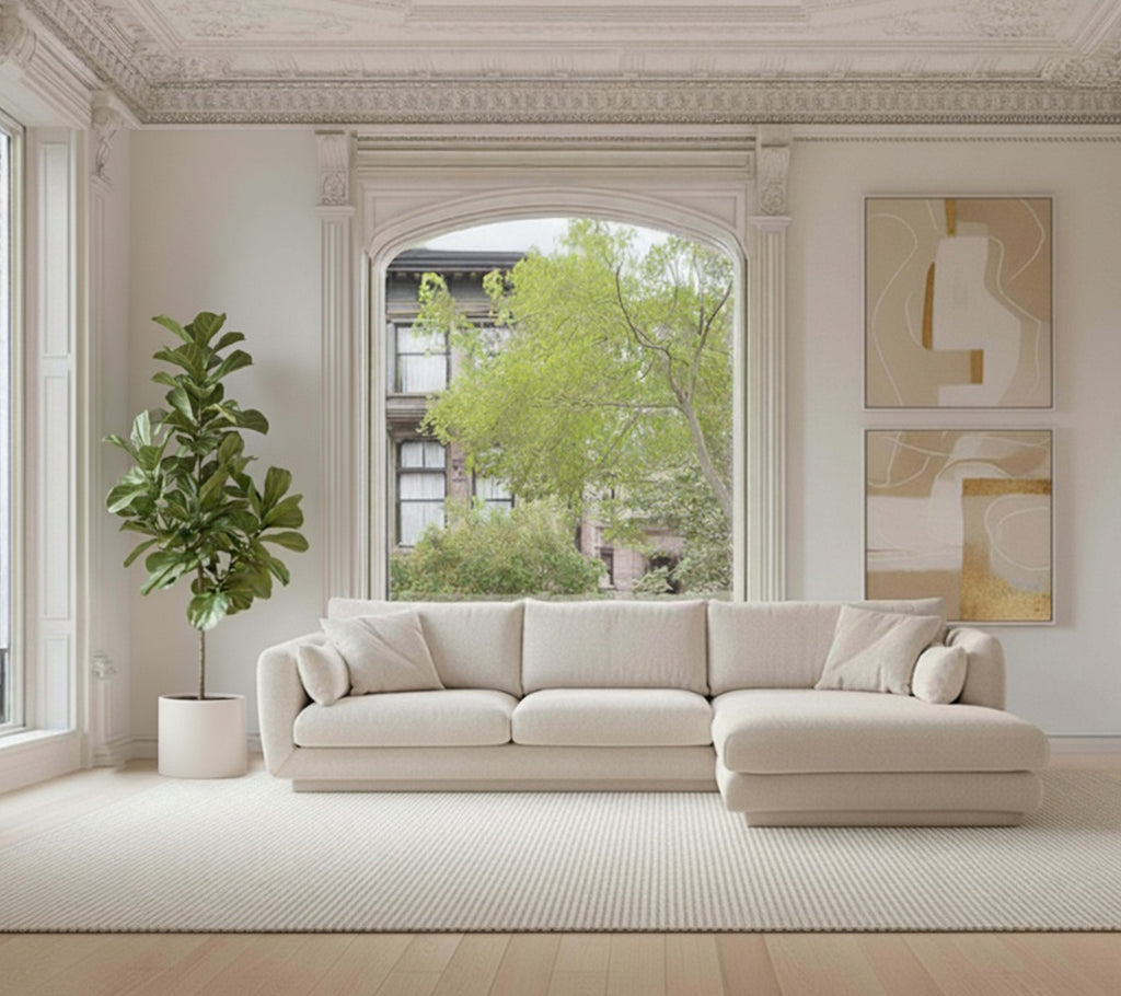 Sofá seccional beige con una planta verde y una alfombra blanca en un ambiente moderno de salón.