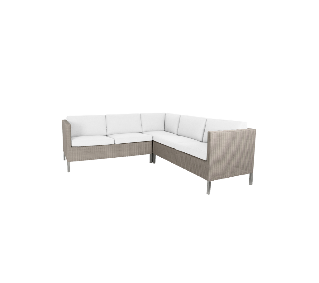 Sofá de esquina elegante con un cojín de tonos claros y un exterior tejido, perfecto para reuniones informales.