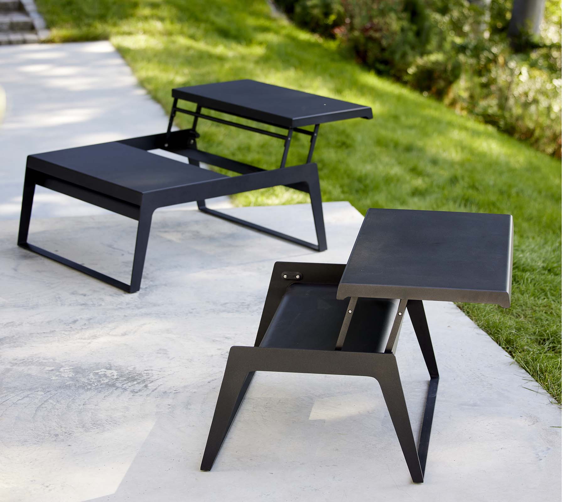 Dos mesas de café modernas y relajantes con diseños elegantes y acabados en negro minimalistas, que muestran versatilidad en estilo y funcionalidad.