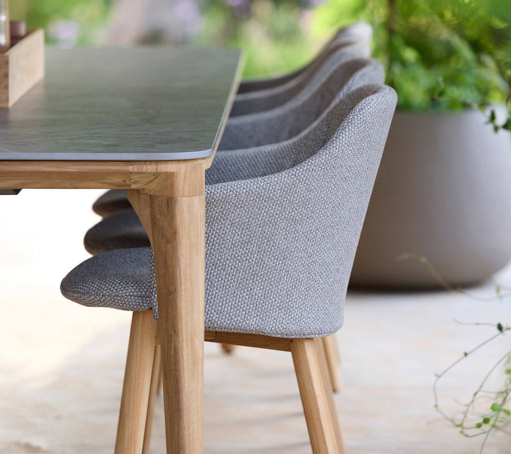 Silla y mesa grises modernas en un entorno exterior sereno.