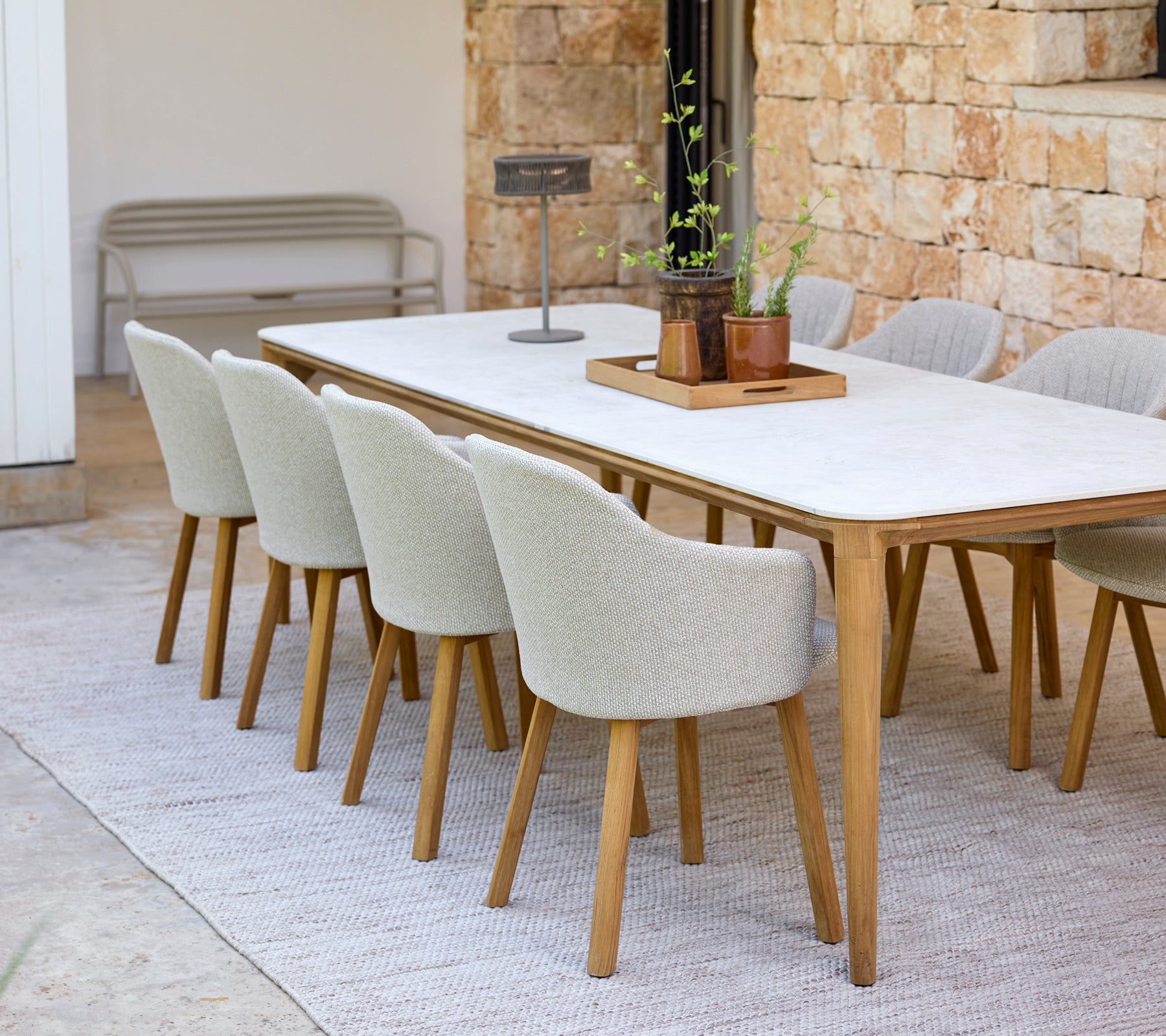Configuración moderna de comedor con una mesa blanca y sillas beige.