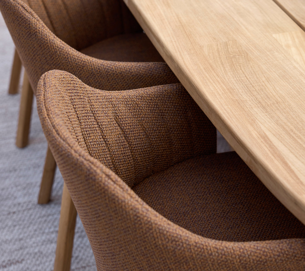 Sillas de comedor marrones combinadas con una mesa de madera en un entorno moderno.
