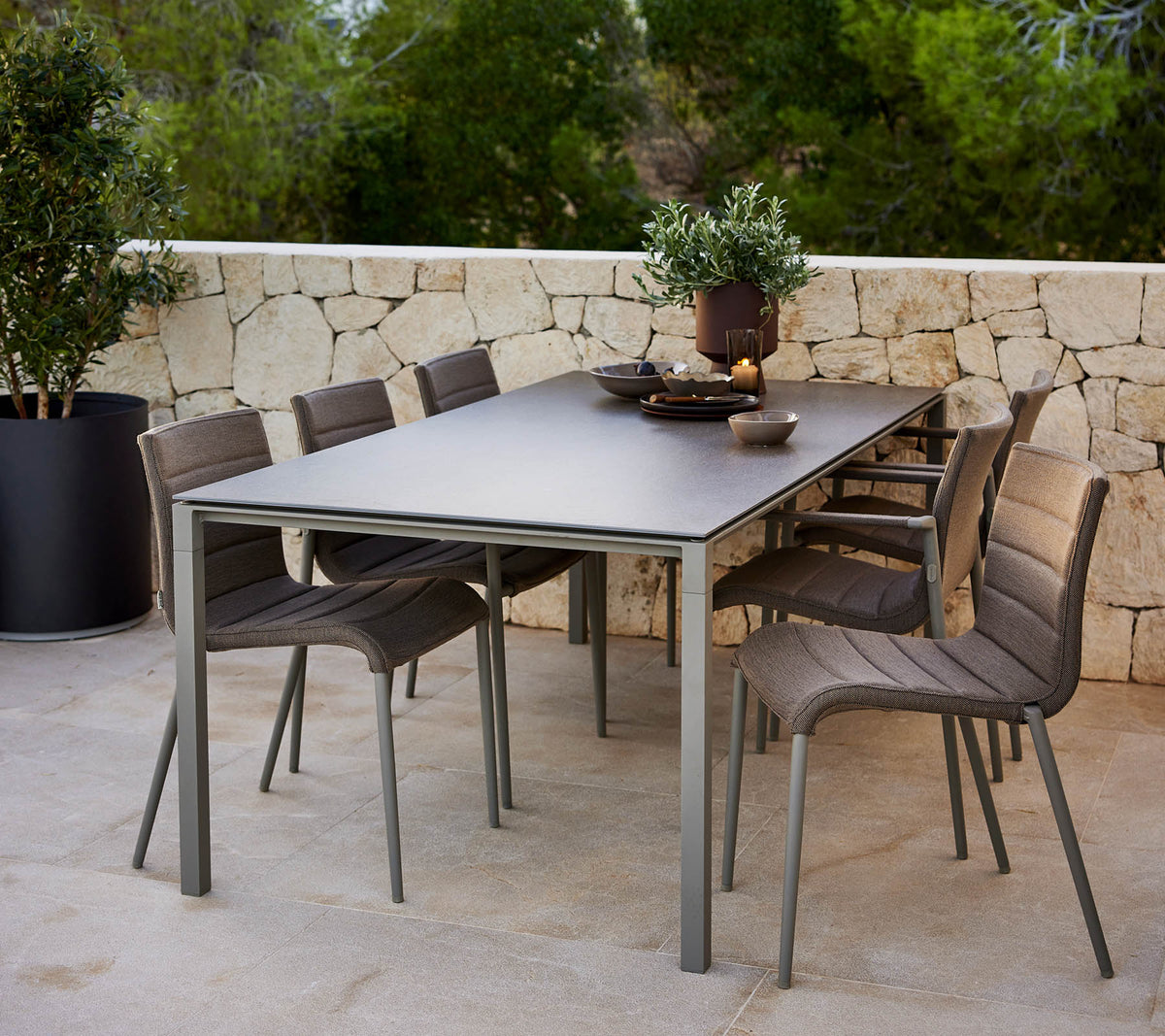 Una mesa pura y elegante con un centro decorativo, rodeada de modernas sillas Core para una cómoda seating.