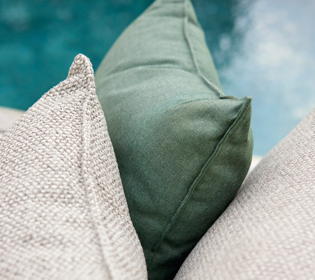 Cojines verdes y grises dispuestos juntos.