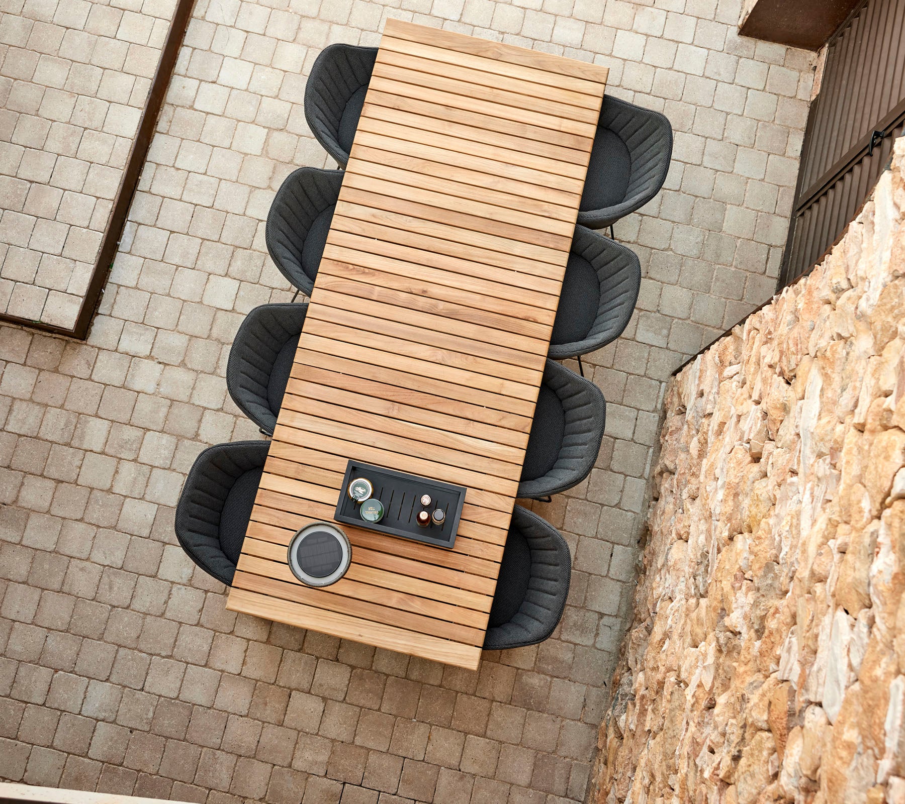 Una larga mesa de madera con un diseño elegante, rodeada de cuatro sillas modernas, con un centro de mesa decorativo.