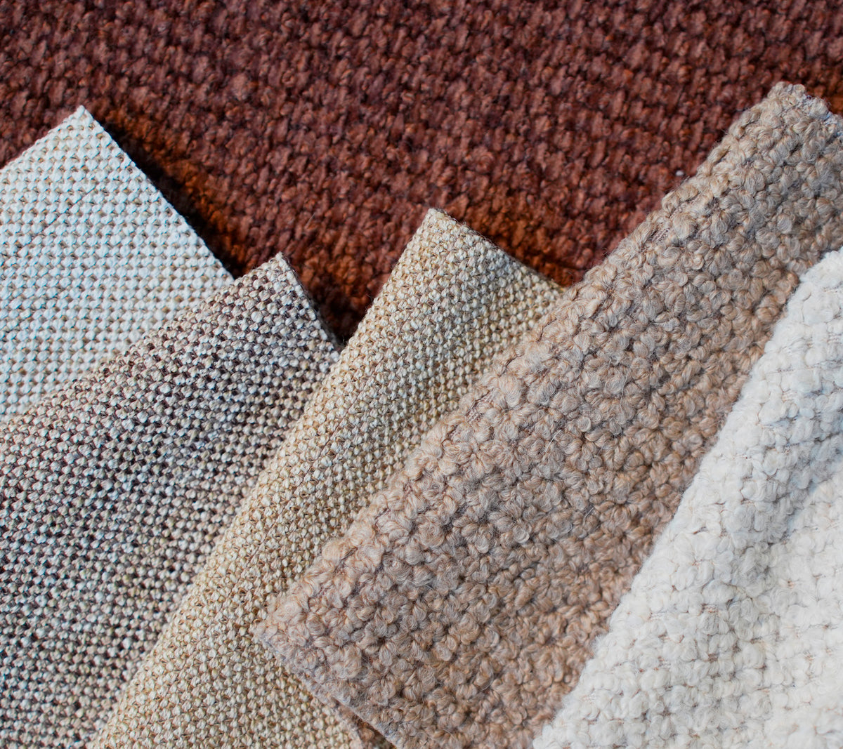 Muestras de varias telas texturizadas en marrón, beige, gris claro y blanco.