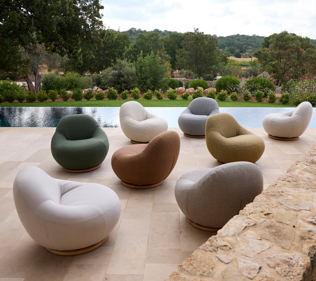 Conjunto de sillas modernas en varios colores dispuestas alrededor de una piscina.