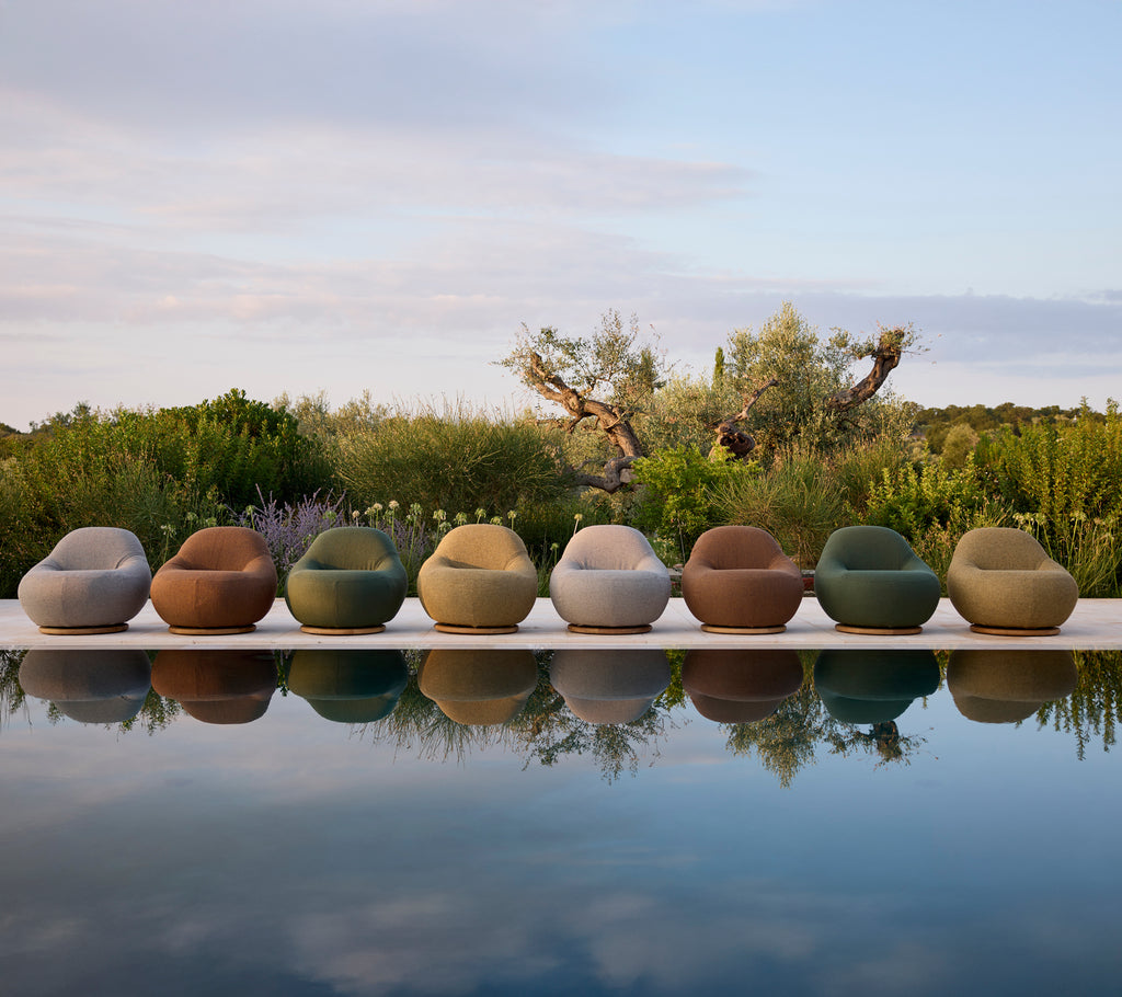 Sillas de exterior contemporáneas de varios colores dispuestas junto a la piscina.