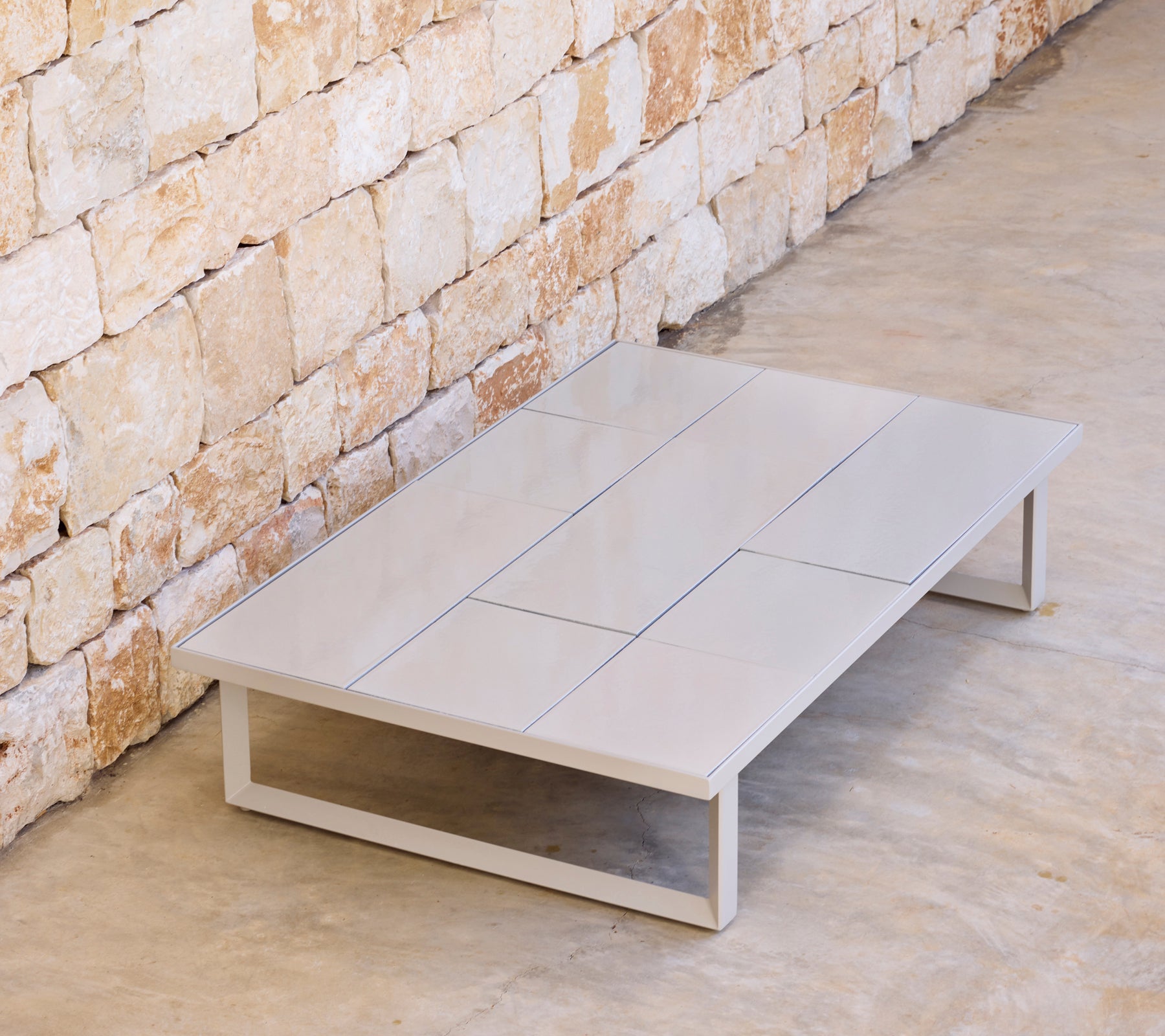 Mesa de café moderna gris con un diseño minimalista en un entorno natural.