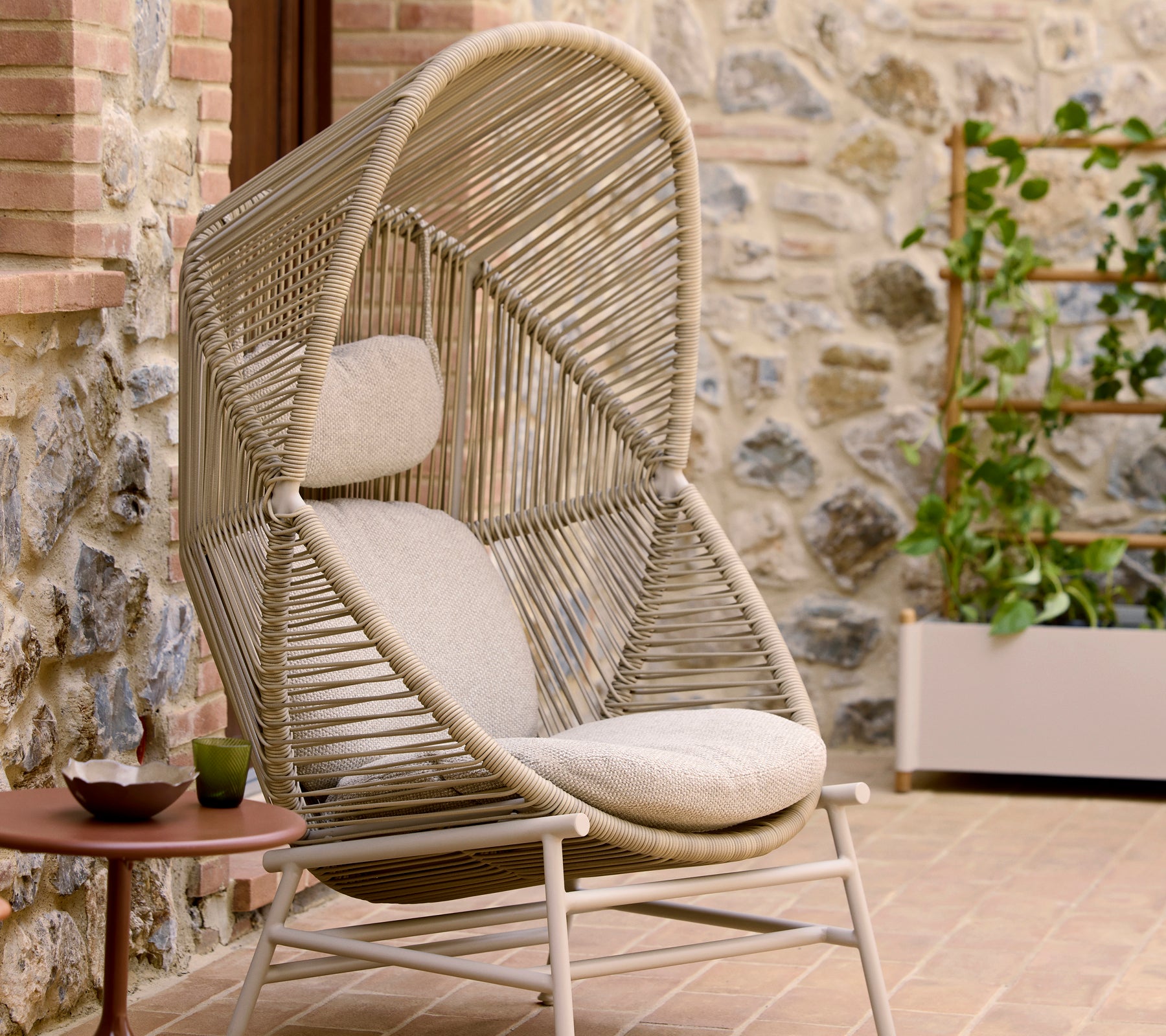 La silla Hive en color arena presenta un diseño tejido único con un asiento acolchado y un distintivo arco superior para mayor comodidad y estilo.