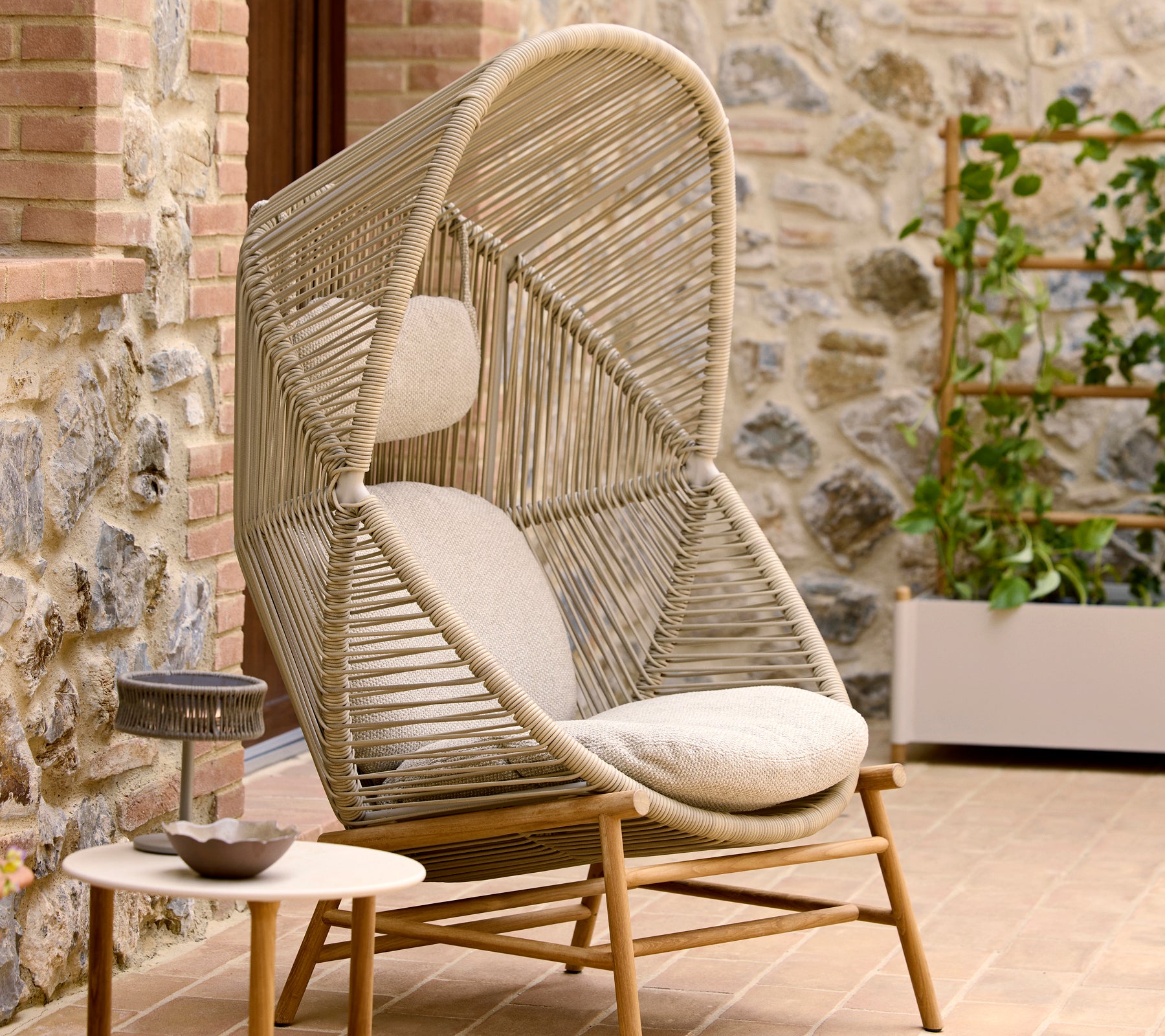 Silla Hive elegante en color arena con un diseño único de torsión, complementada con cojines mullidos para mayor comodidad.