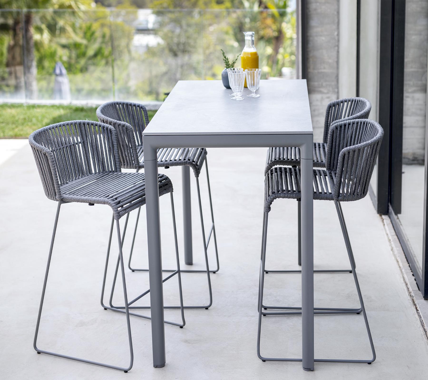 Conjunto de comedor moderno que incluye una mesa elegante y cuatro sillas de respaldo alto con un diseño minimalista, ideal para reuniones informales.