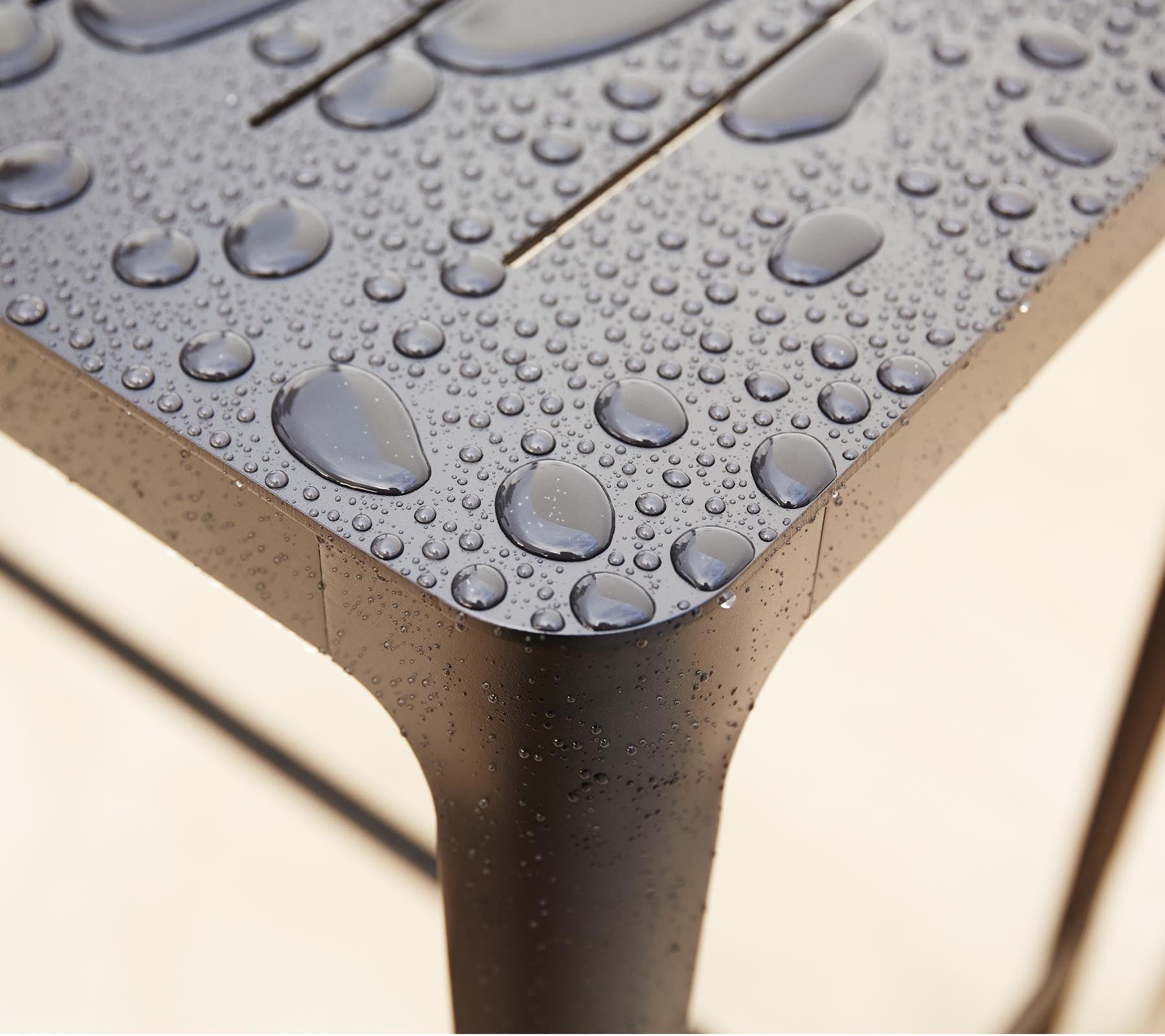 Primer plano de una superficie texturizada con gotas de agua, destacando el diseño elegante y los detalles del material.