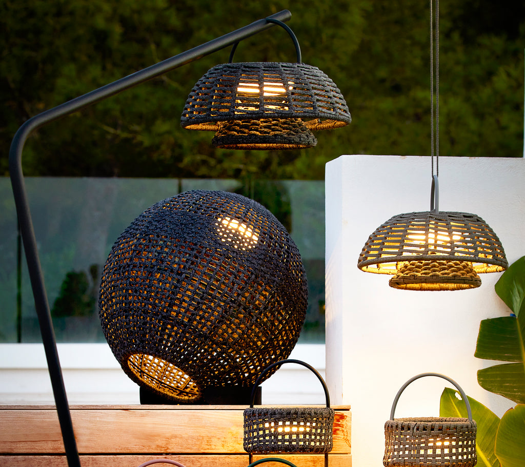 Lámpara de ilusión gris redonda con un intrincado diseño tejido, acompañada de lámparas colgantes más pequeñas, creando una disposición de iluminación elegante y acogedora.