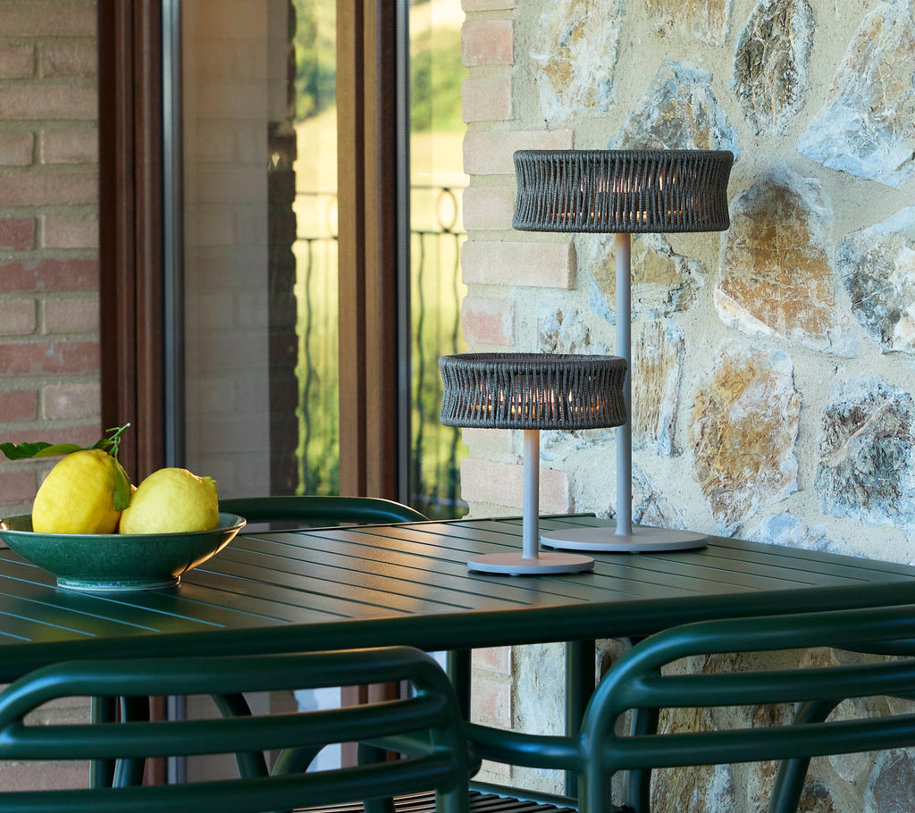 Lámparas de ilusión pequeñas y medianas sobre una mesa con un cuenco de limones, rodeadas de elementos de piedra y vidrio.