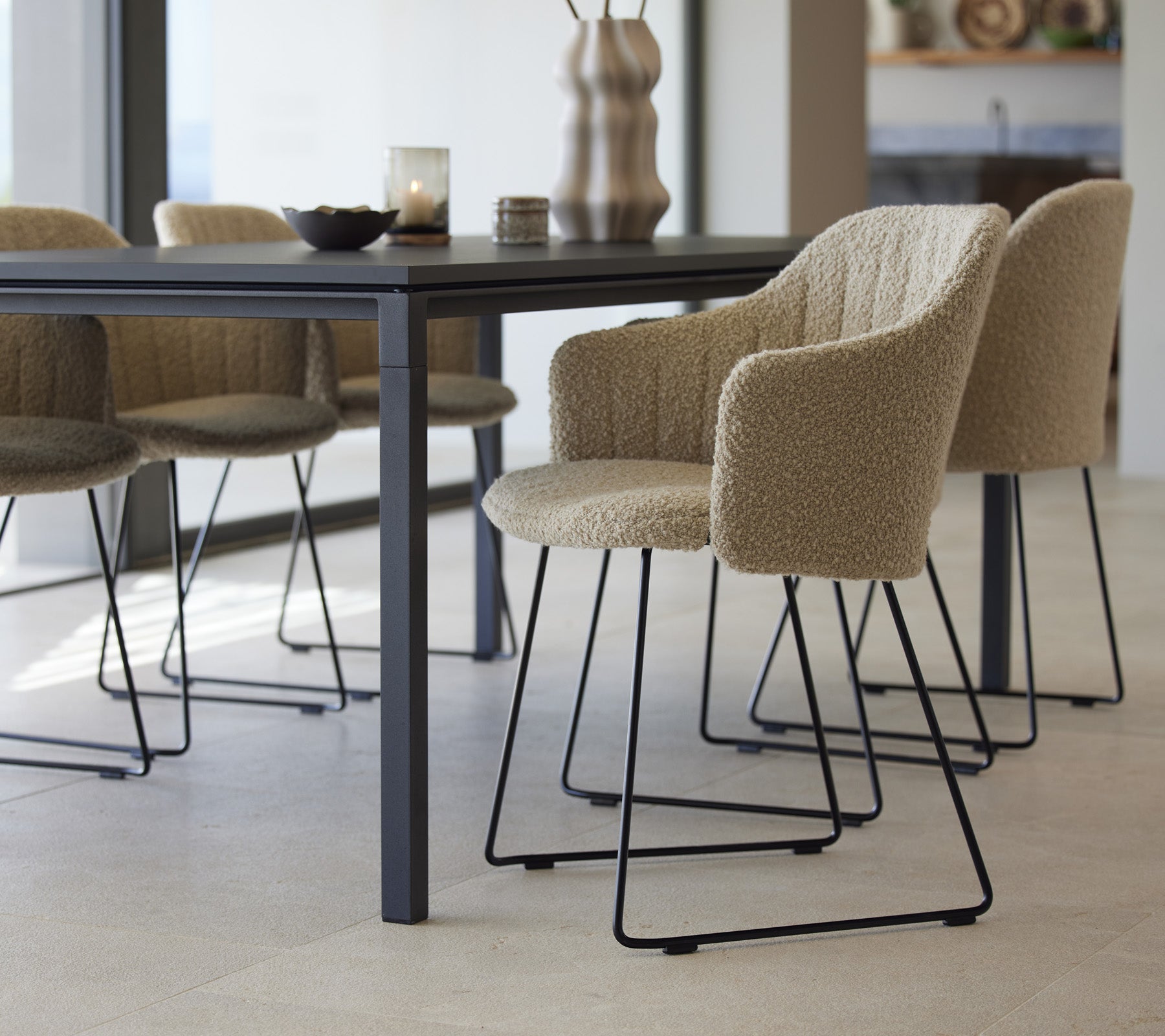 Una mesa de comedor elegante con sillas texturizadas, con un diseño moderno y elementos minimalistas, lista para una experiencia gastronómica acogedora.