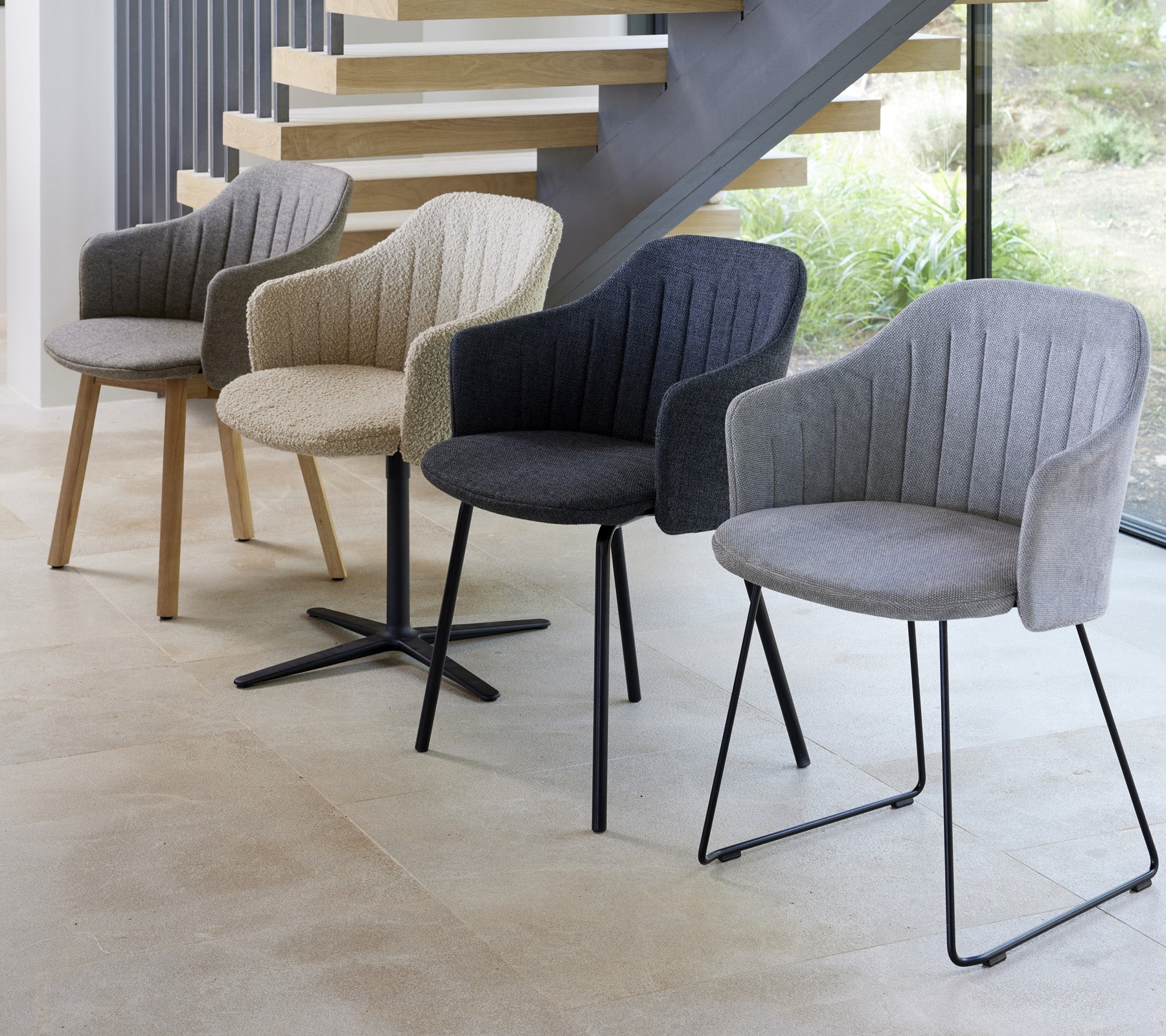 Cuatro sillas modernas en diferentes colores y estilos expuestas en un entorno contemporáneo, mostrando sus diseños únicos.