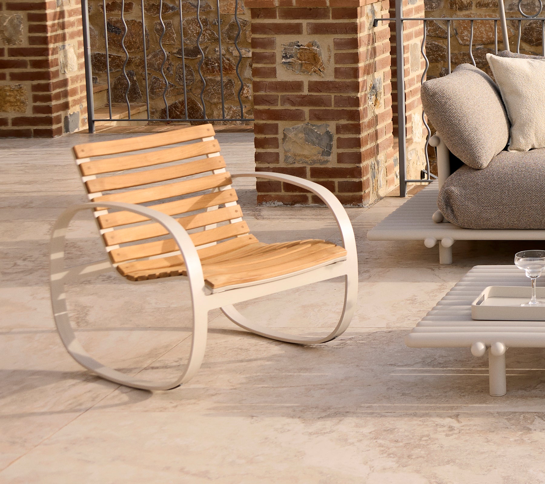 Sillón mecedora elegante con un marco de aluminio elegante y listones de madera, perfecto para relajarse en espacios contemporáneos.
