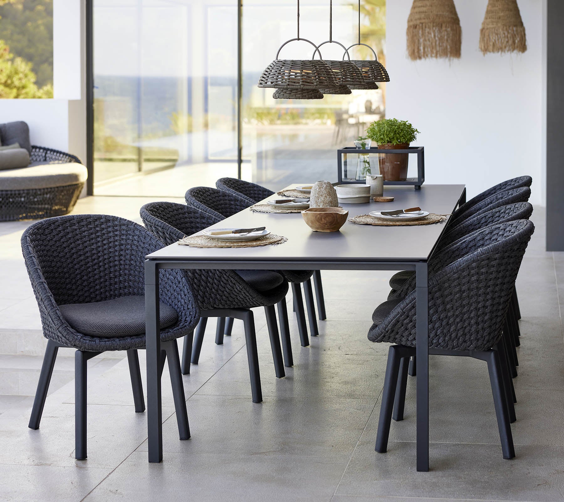 Una elegante disposición de comedor con una mesa de comedor pura, sillas de pavo real y una lámpara de ilusión, que realza una estética moderna.