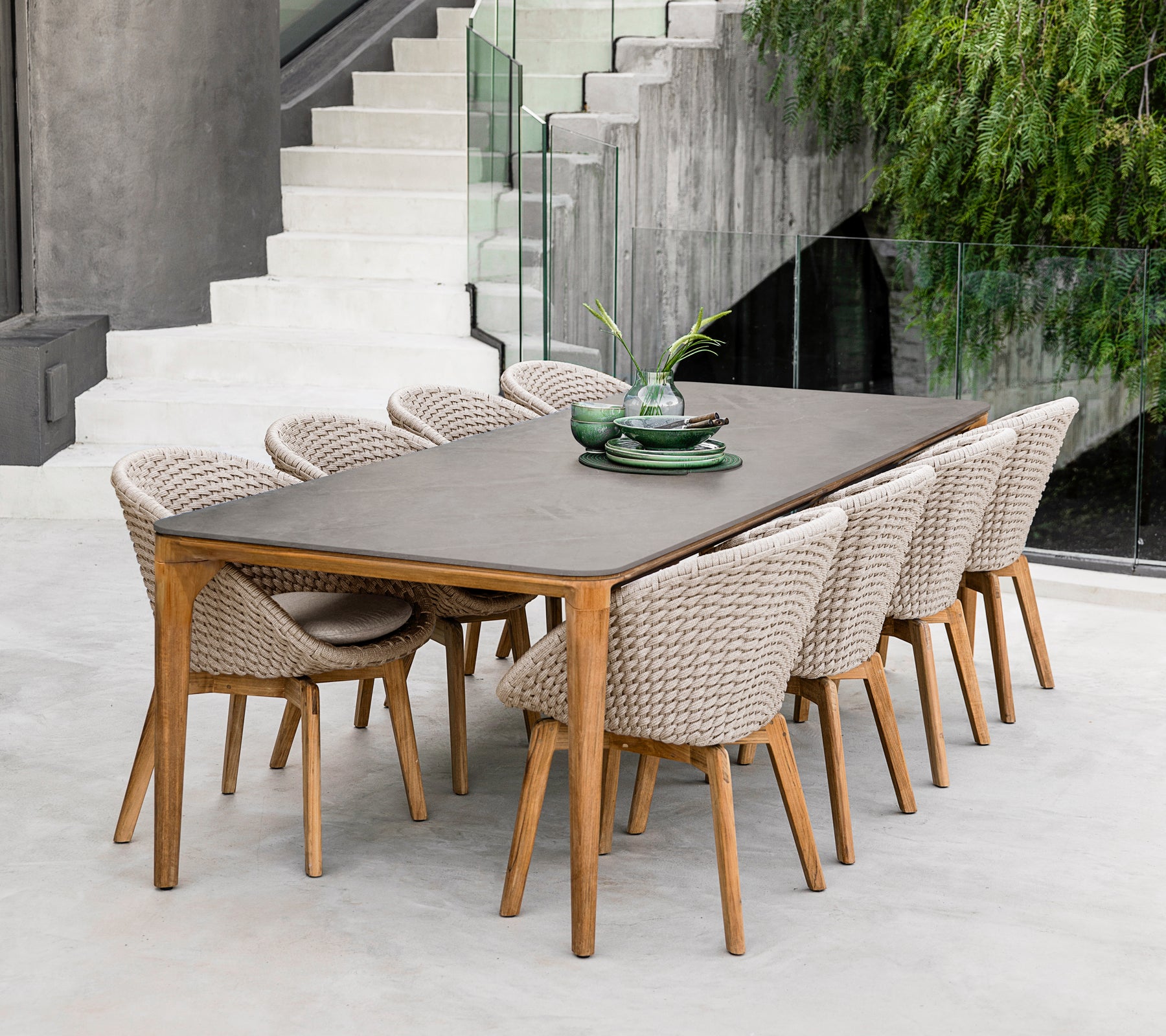 Mesa de comedor marrón moderna con sillas trenzadas en un entorno contemporáneo.