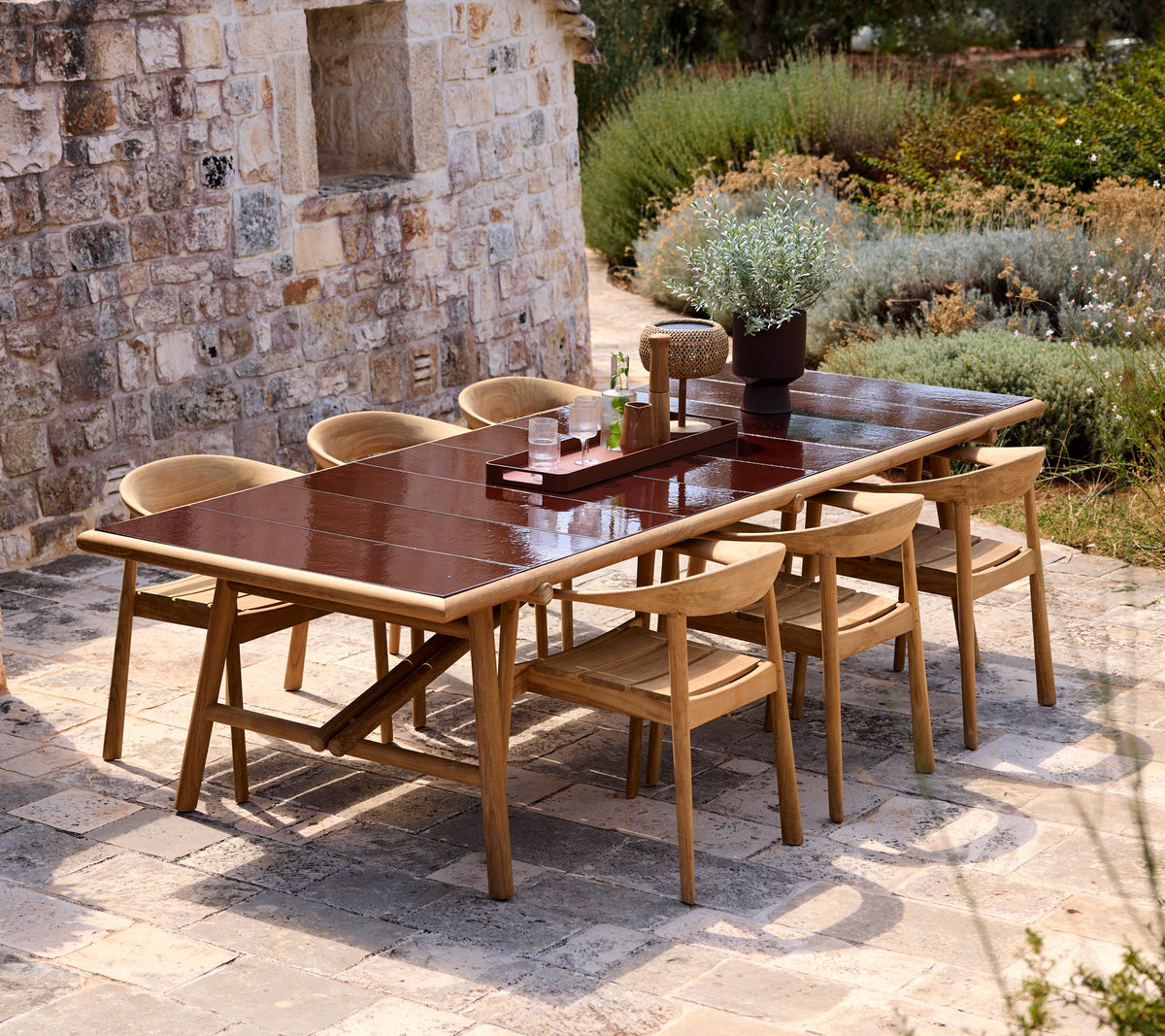 Mesa de comedor marrón con sillas beiges en un entorno exterior moderno.