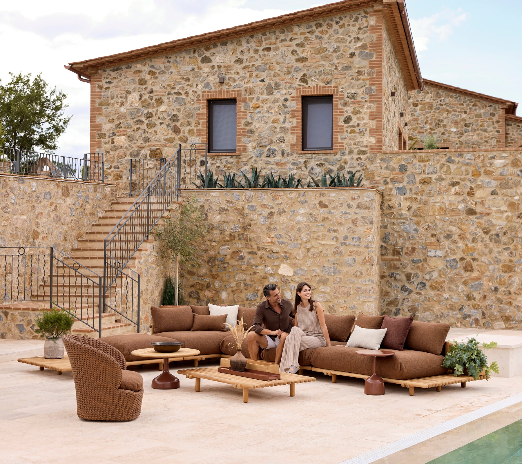 Área de salón elegante con muebles de teca y asientos cómodos, ideal para relajarse con alguien especial.