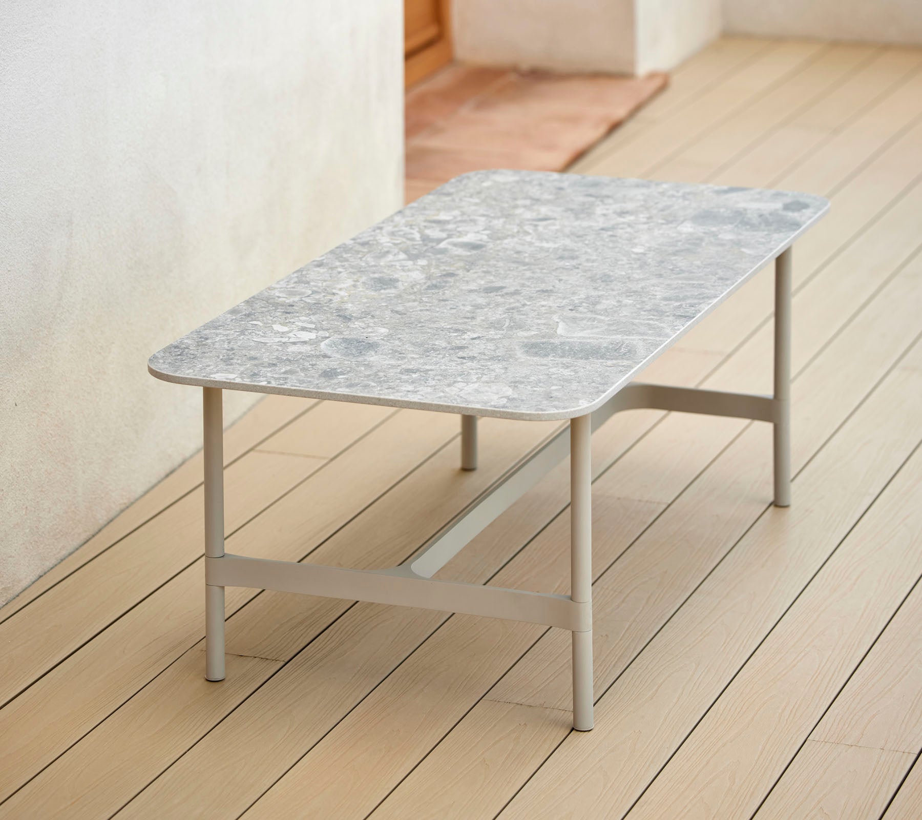 Una mesa de café rectangular elegante con una parte superior con diseño y patas de metal robustas, perfecta para una decoración moderna.