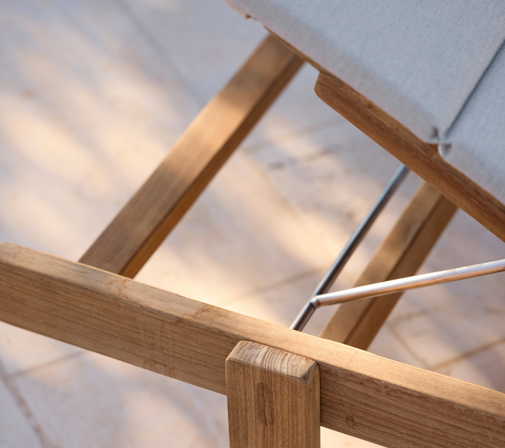 Silla de lounge moderna con un cojín gris y marco de madera.