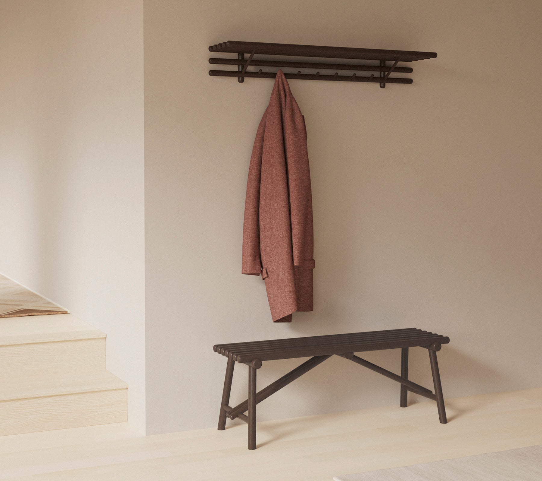 Un banco minimalista con una estantería encima, que muestra un abrigo colgado de ganchos, enfatizando la simplicidad y la funcionalidad en el diseño.