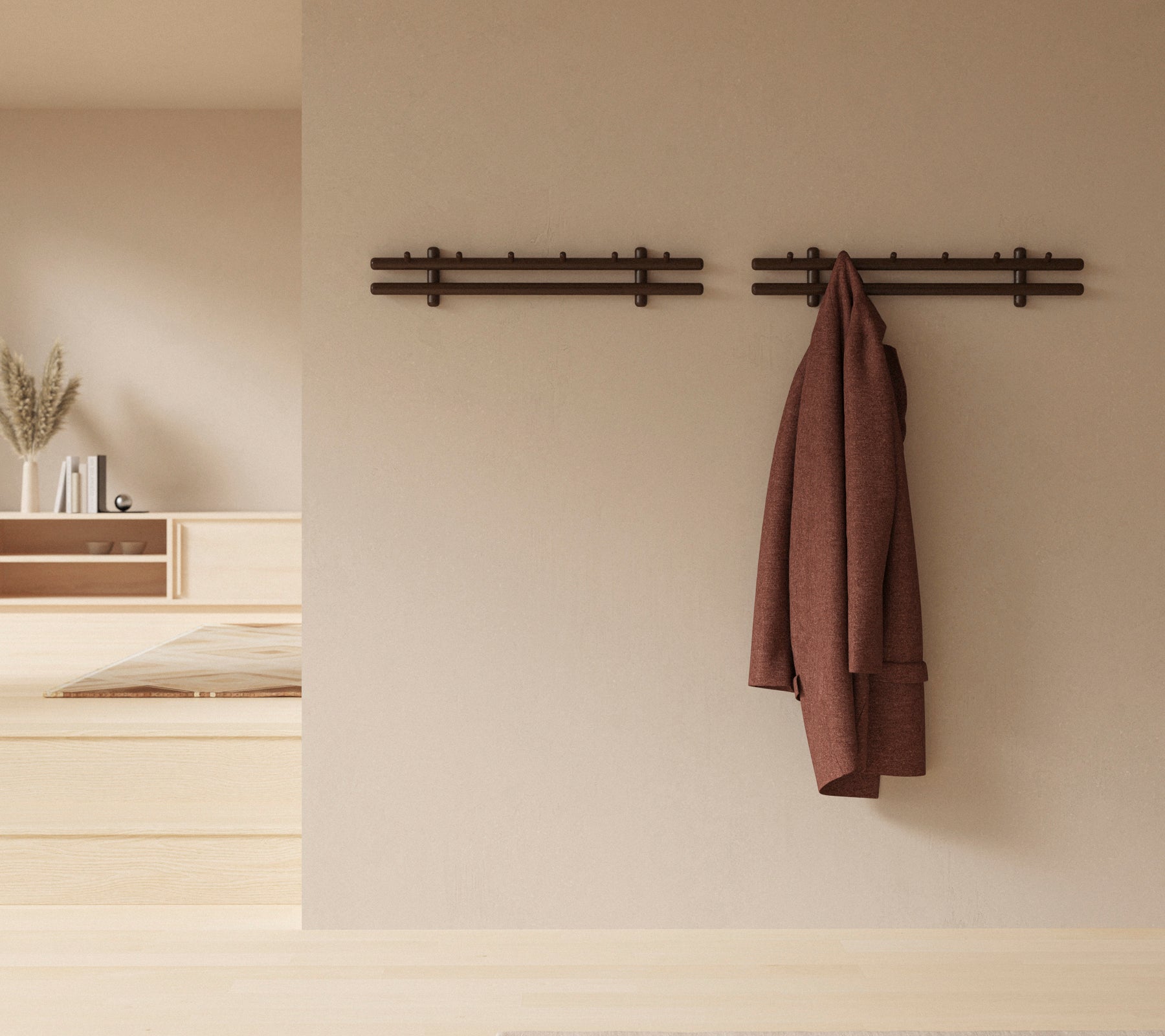 Una exhibición de pared minimalista con palos de madera que sostienen un abrigo y un grupo de trapos, mejorando la estética decorativa rústica.