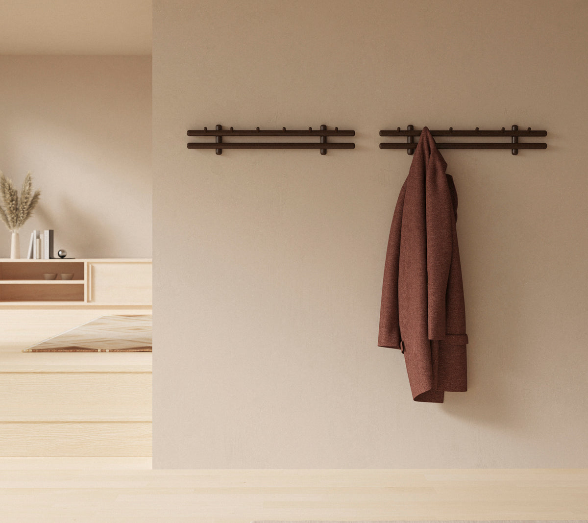 Una exhibición de pared minimalista con palos de madera que sostienen un abrigo y un grupo de trapos, mejorando la estética decorativa rústica.