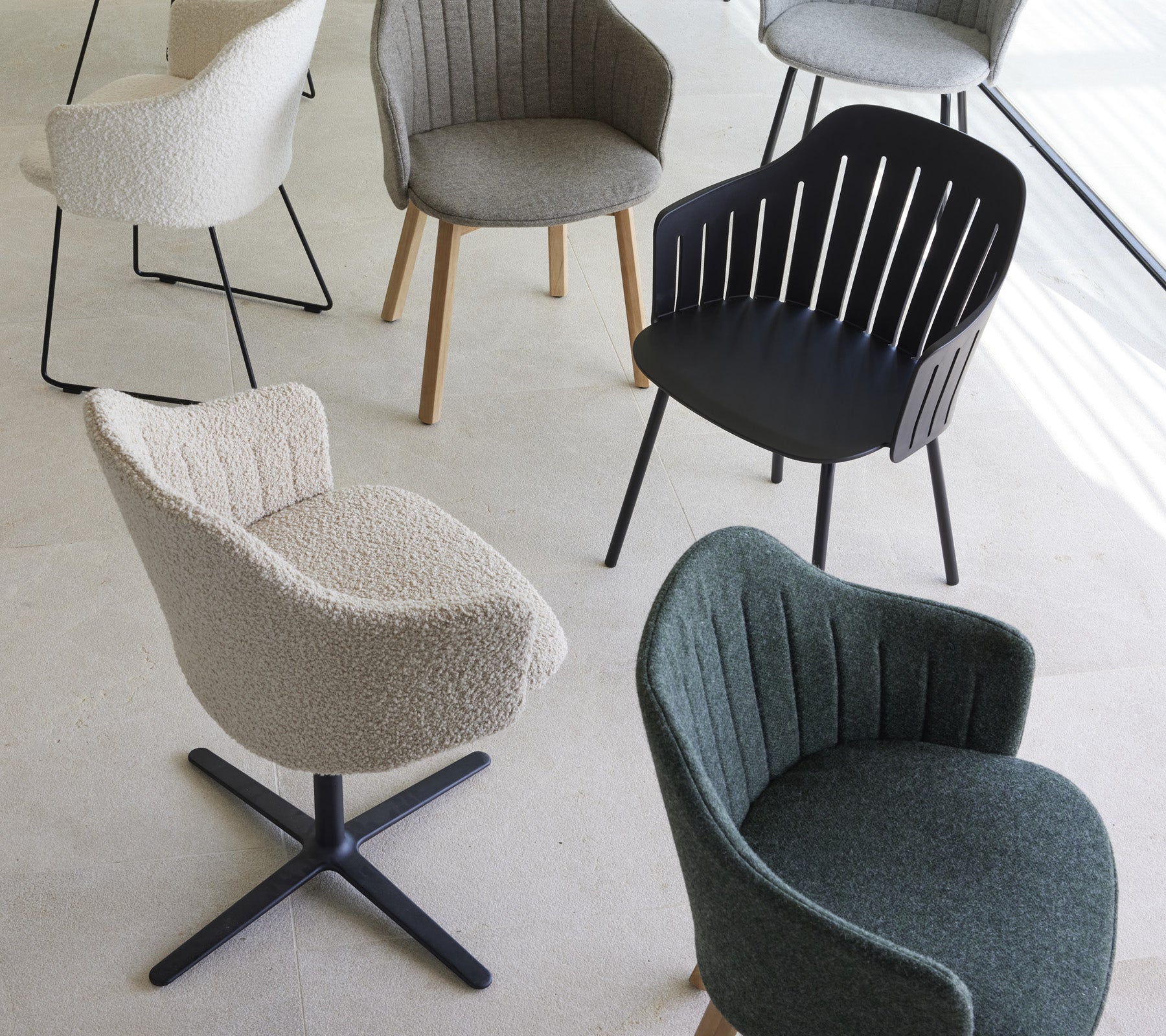 Una colección de sillas elegantes en varios diseños y colores, con texturas y formas únicas, adecuadas para espacios de vida modernos.